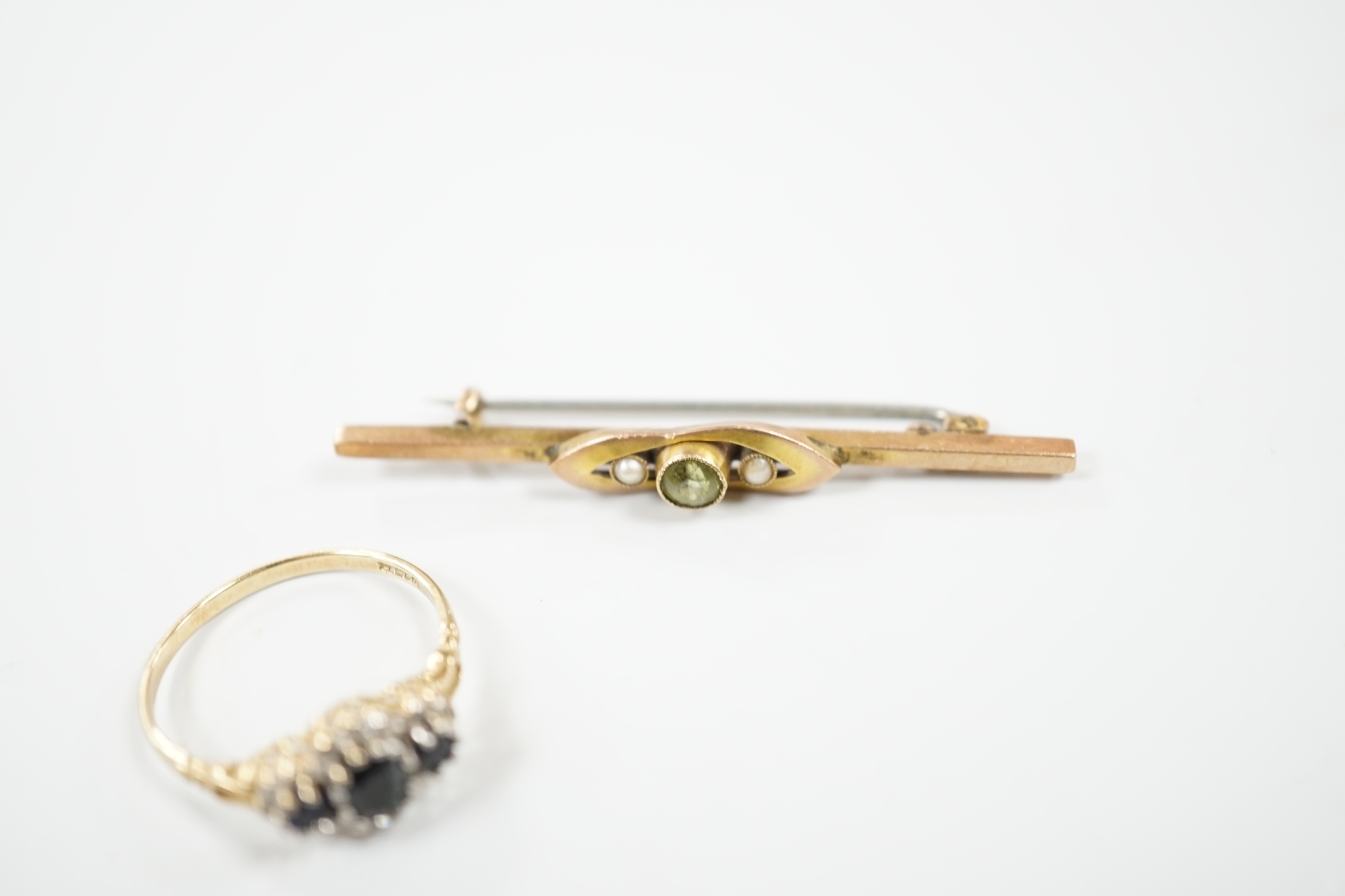 A modern 9ct gold, sapphire and diamond set triple cluster ring and an early 20th century 9ct, peridot and split pearl set bar brooch, gross weight 5.6 grams.